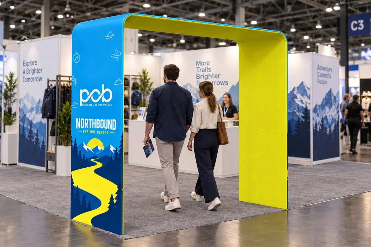 Square arch display with blue and yellow branded graphics welcoming visitors into a trade show booth