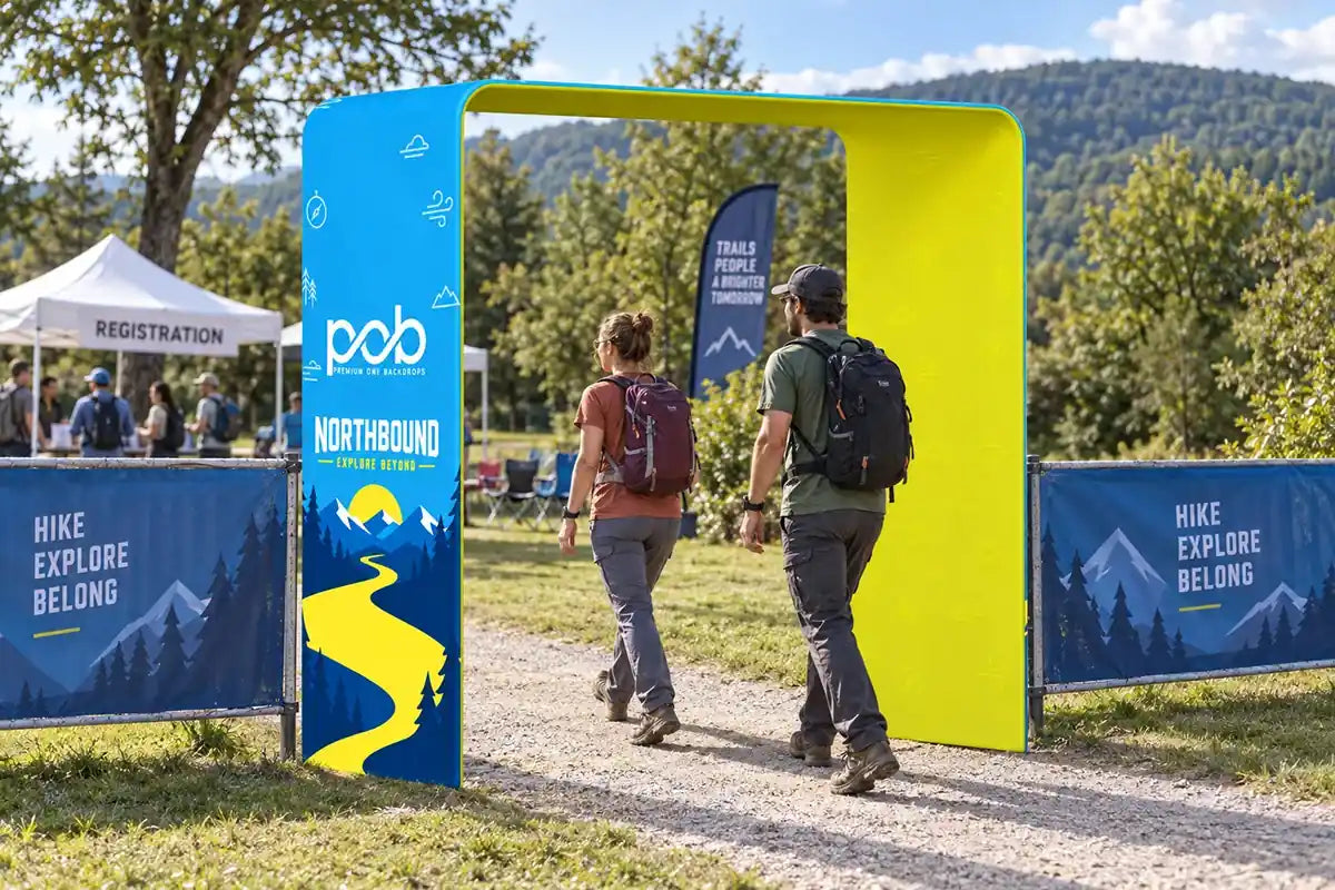 Square arch display with mountain graphics marking the entrance to an outdoor hiking event