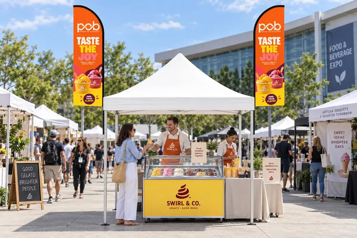 White pop up canopy with two promotional feather flags at an outdoor food and beverage event